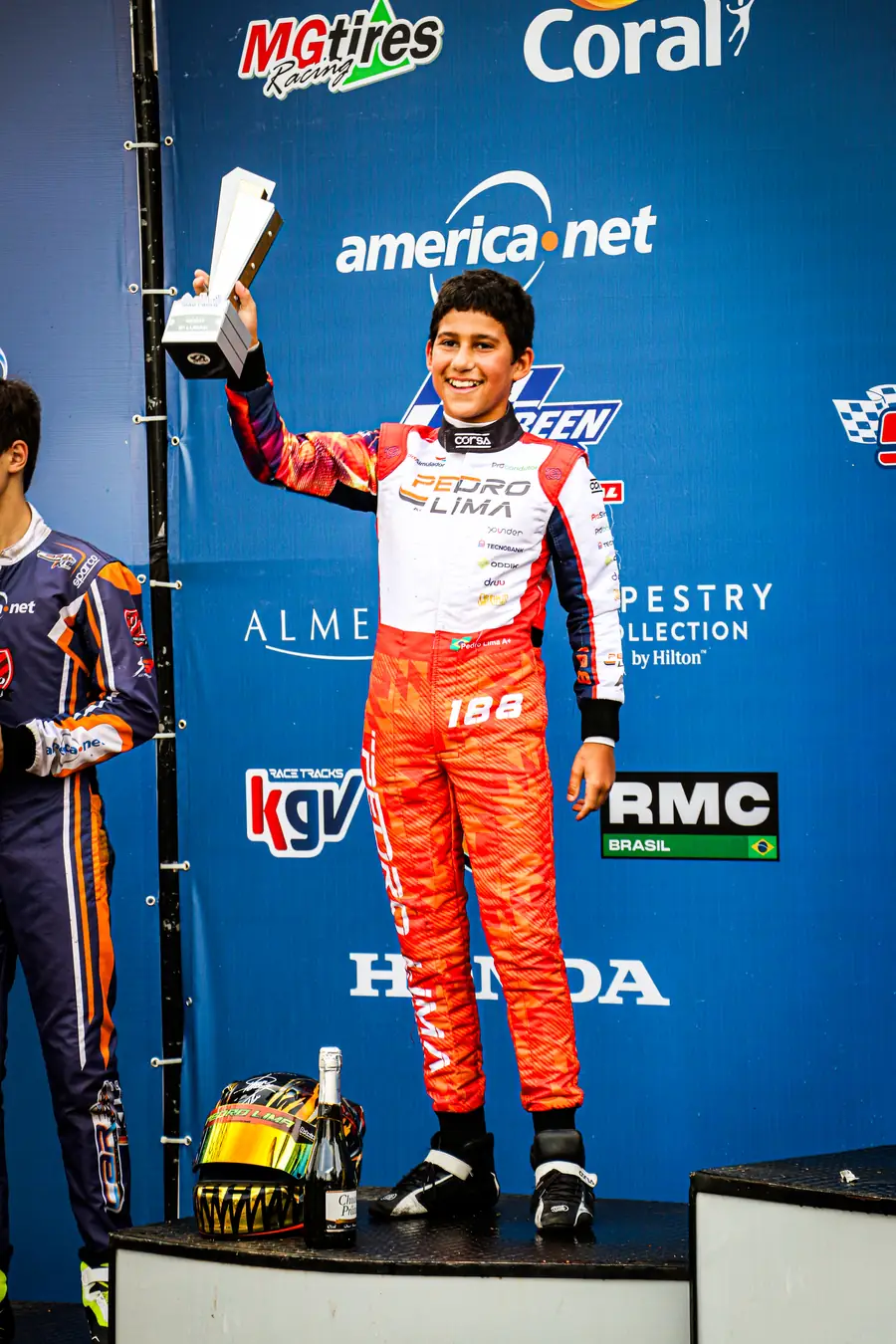 Pedro no pódio do kart erguendo um troféu