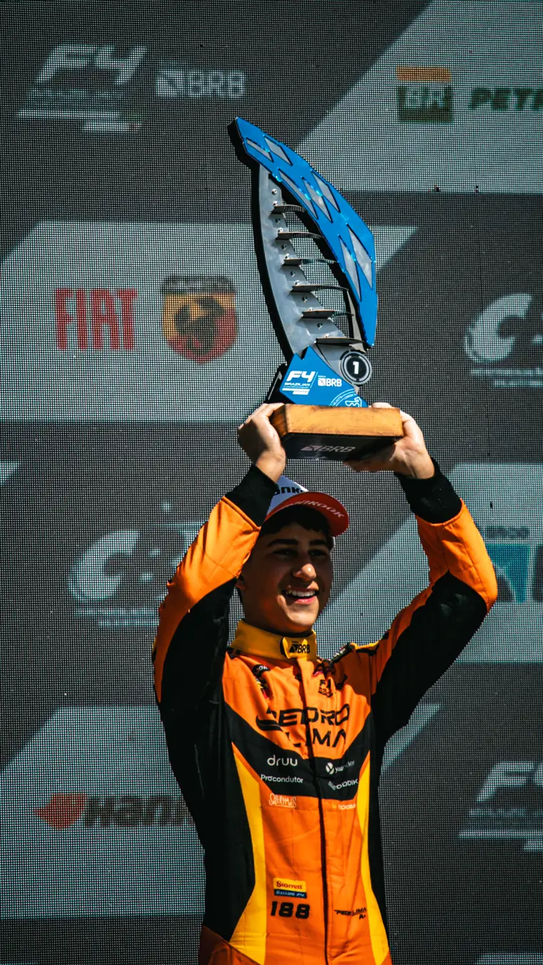 Pedro erguendo o troféu de vencedor da F4 Brasil